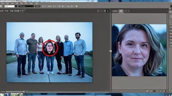 A close-up screen capture of a photo editor canvas showing a wide group photograph on the left side with five people standing together and one face circled in red as the swap target, and on the right side the same target face cropped and enlarged into its own working frame ready for swapping, neutral grey UI panels around the canvas, lit by even cool screen glow from the monitor, calm focused workspace atmosphere.