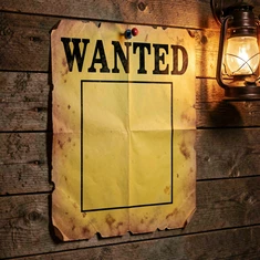 A weathered Old West wanted poster printed on yellowed paper with bold black serif type reading "WANTED" at the top and a rectangular portrait space in the center, pinned to a rough wooden plank wall, warm directional lantern light from the upper right, aged paper texture with torn edges, vintage Western graphic design style.